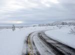 A snowy road under a cloudy sky