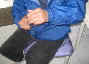 A Dena'ina Athabascan elder shows attendees at culture camp how to set a snare.