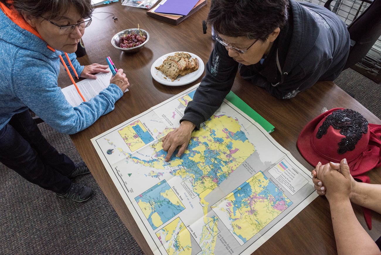 two people pointing at a map