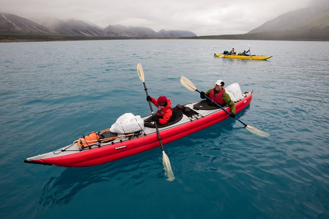 Two brightly colored kayaks pass each other on the deep turquoise water at Twin Lakes.