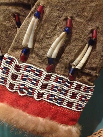 closeup of beads and bone artwork on moose hide gloves