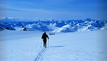 Cross country skier heads towards plane sitting in snow on skies. Cross country skier heads towards plane sitting in snow on skies.