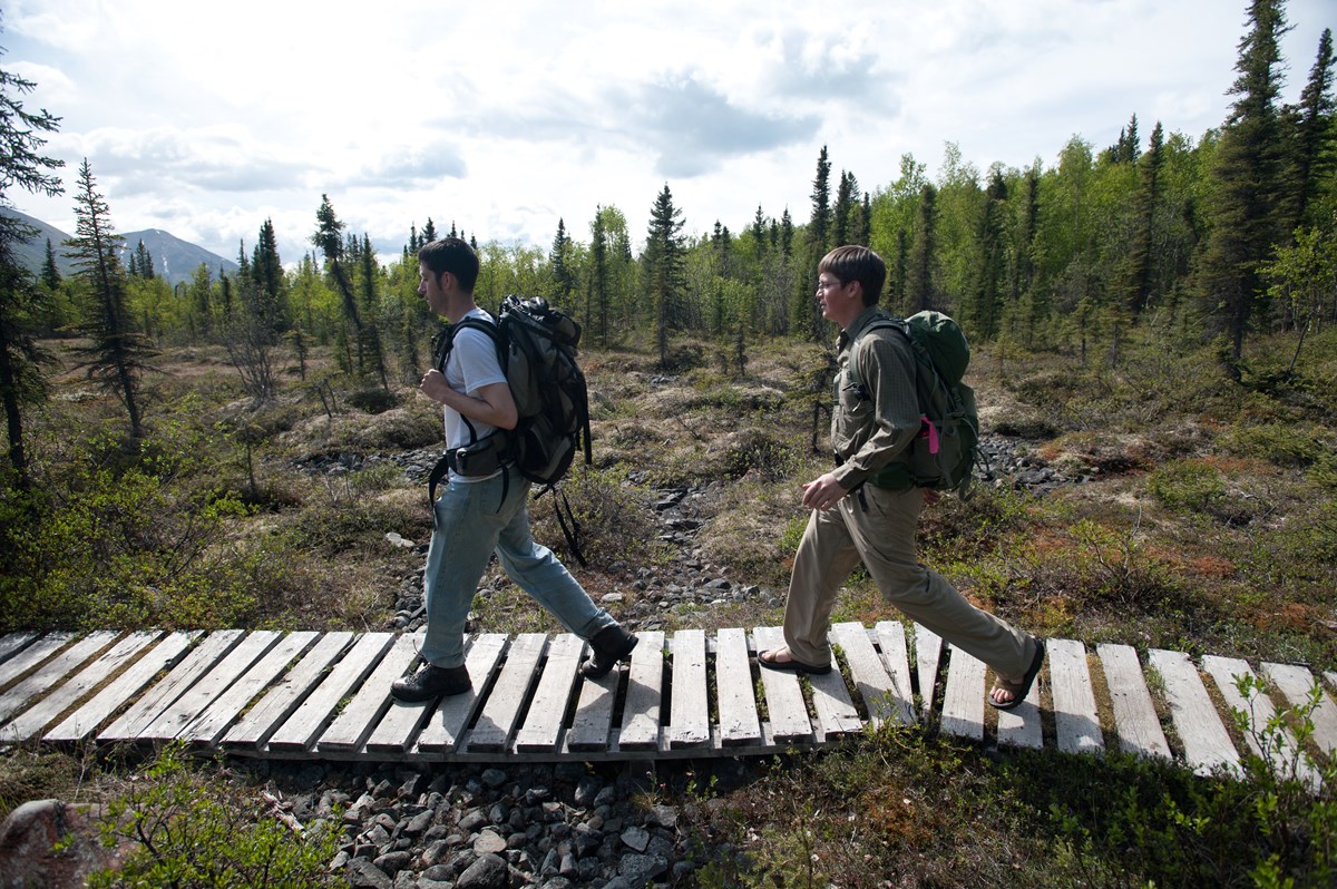 2 hikers on a boardwalk 2 hikers on a boardwalk