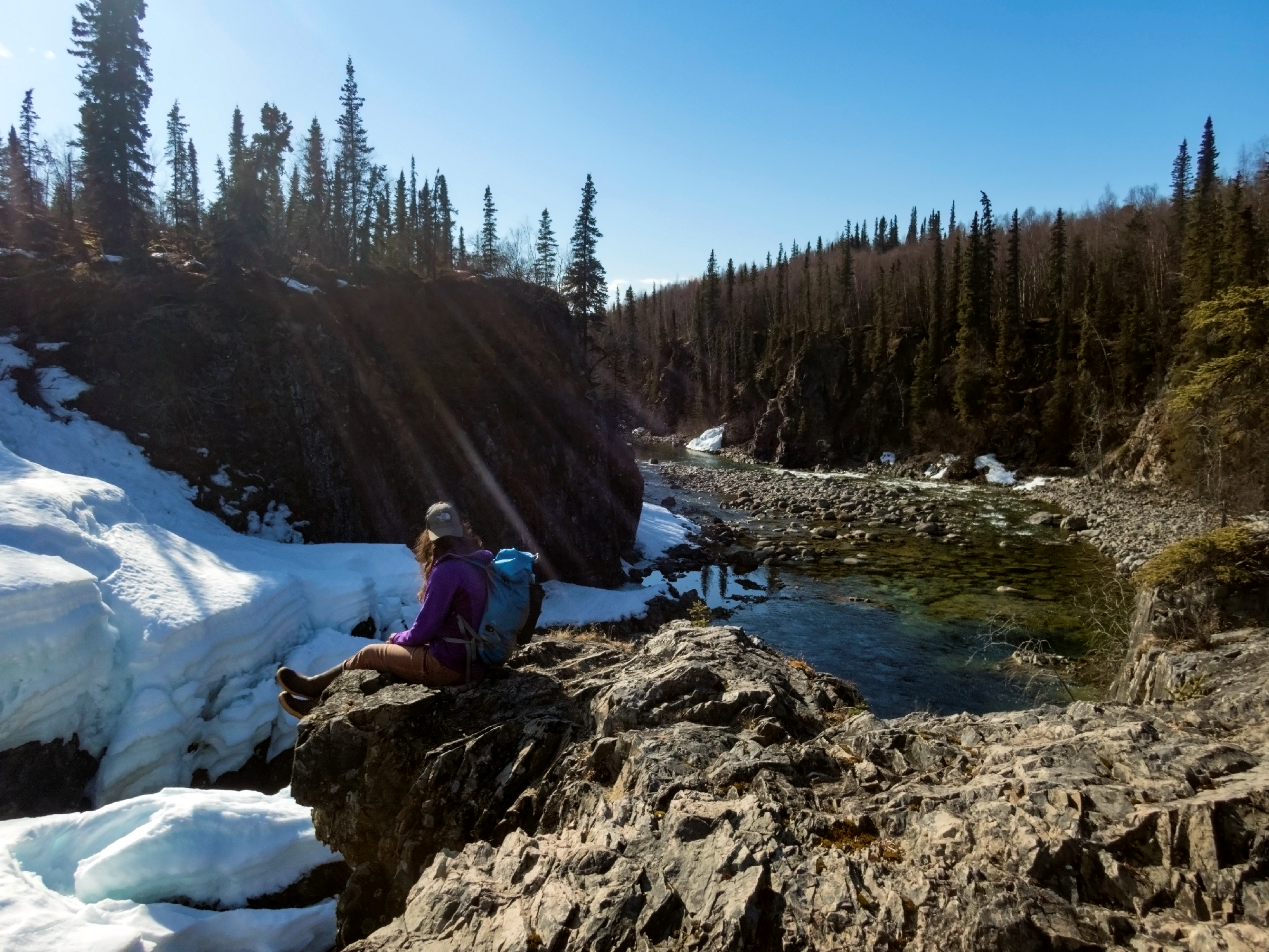 a hiker sits on top of a waterfall