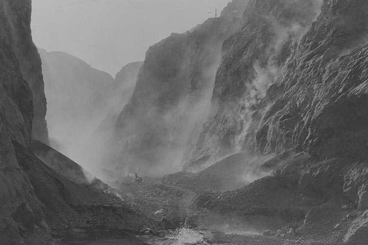 Hoover Damn site, 1934 Explosives stripping canyon walls at Boulder Dam site, 1934.