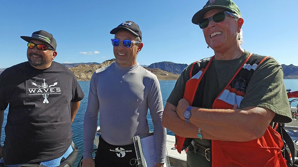 3 participants pose for a photo during meeting on the lake.