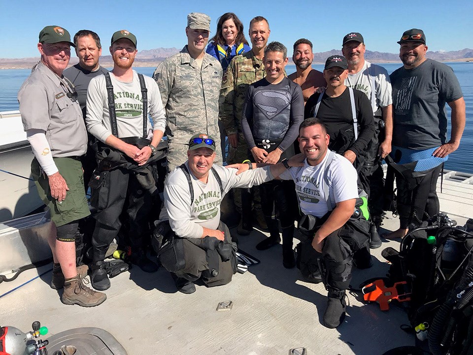 The team of divers pose on the deck of the dive boat on a sunny day before the dive.