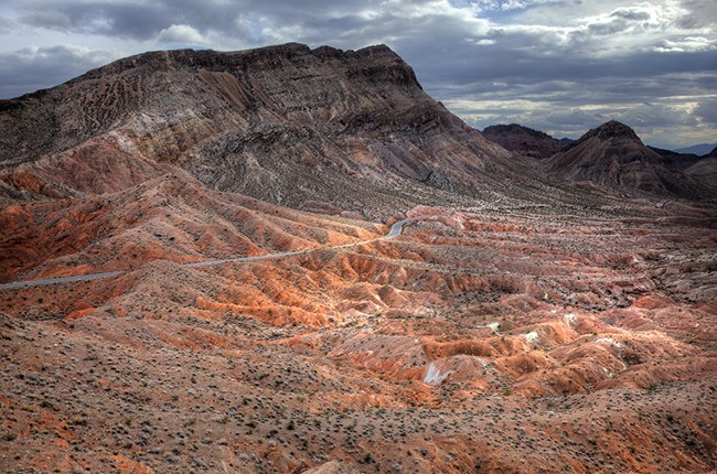 A highway winds through vast redstone mountains.