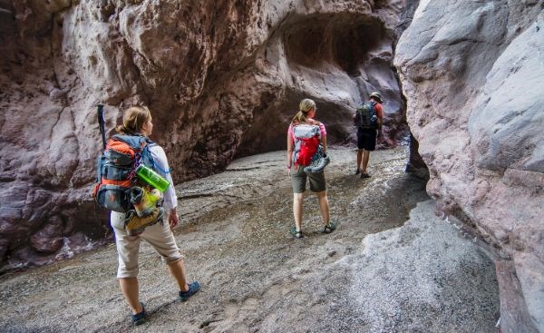 Three hikers walking through rocks