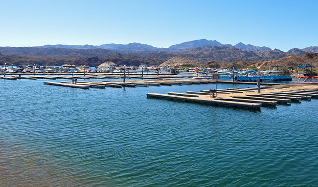 Photo of a body water with marina slips and rugged hills in background