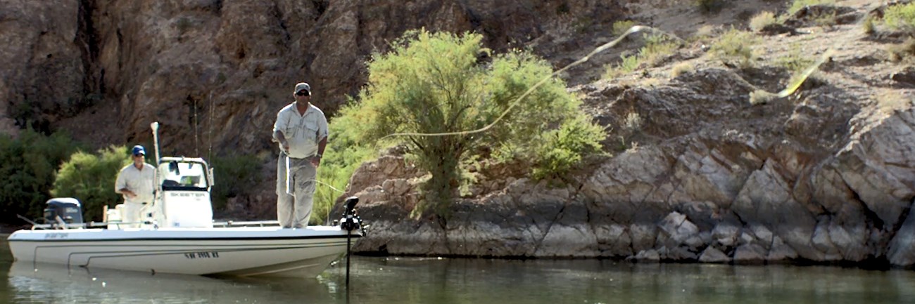 an angler casts his line into the lake from a fishing boat