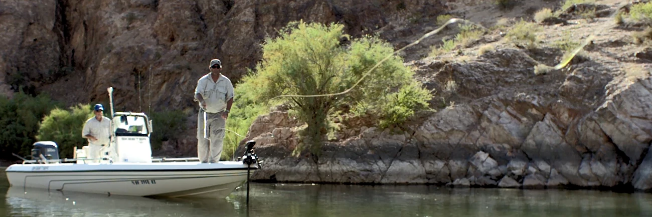 Fishing at Lake Mead an angler casts his line into the lake from a fishing boat