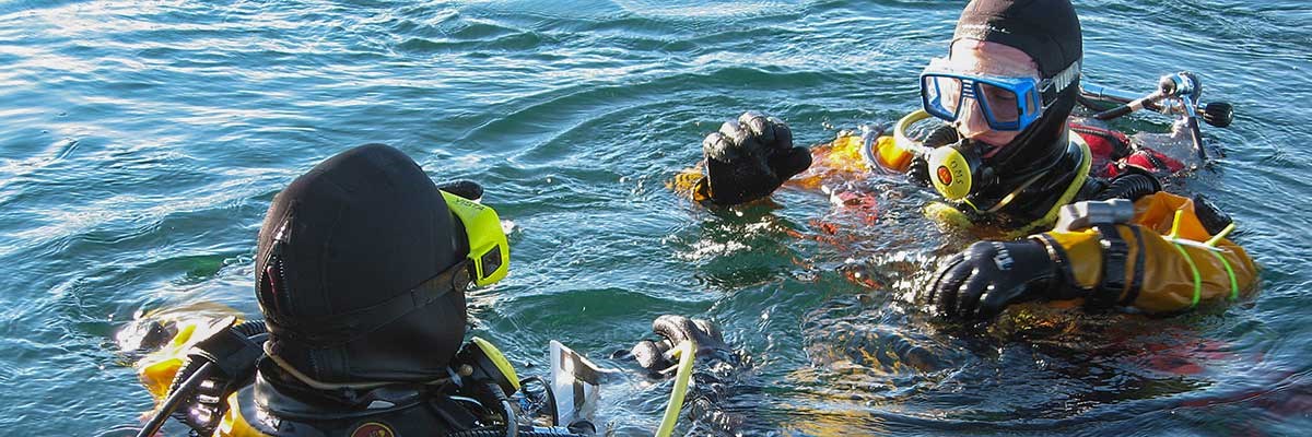 Head and shoulders view of two scuba divers in water