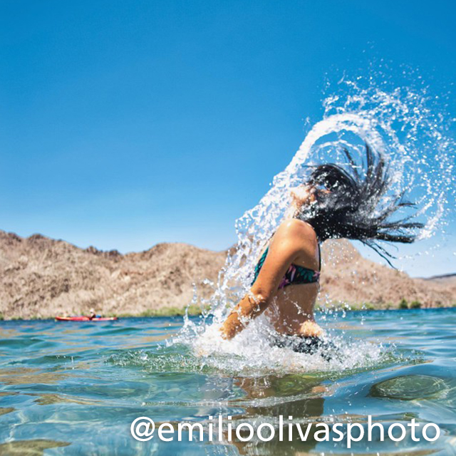 woman flipping hair in turquoise lake water
