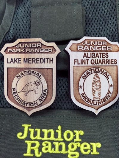 Two wooden Junior Ranger Badges for Lake Meredith and Alibates Flint Quarries.  They ave brown.