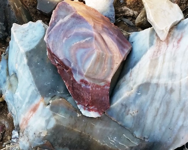 Several flint pieces showing the  many colors of Alibats flint:  grey, blue, dark red, and white.