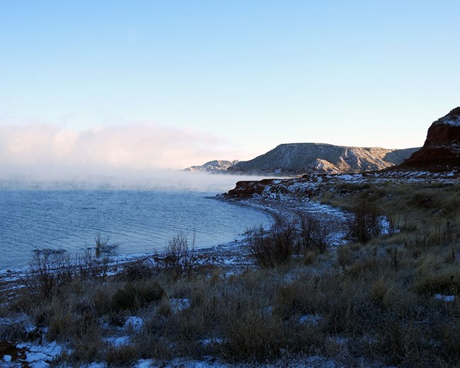 Steam rising from the lake on a snowy morning