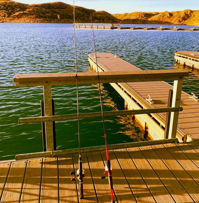 Two fishing poles on the dock at Sanford Yake on a sunny morning.