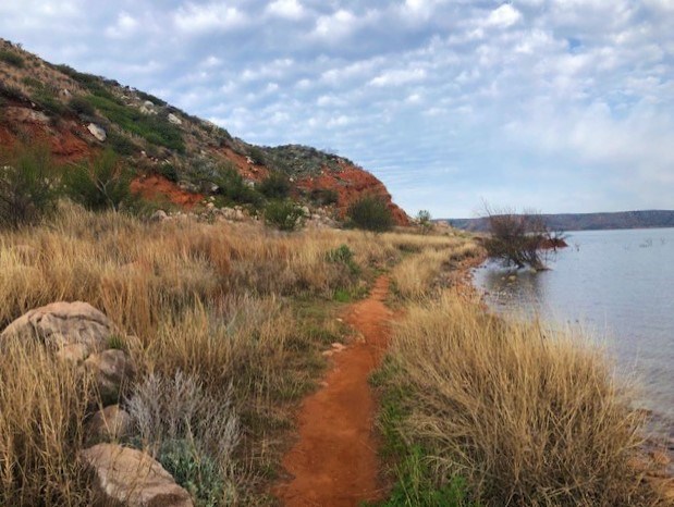 Along the shoreline of Lake Meredith on Turkey Creek Trail.  Numerous clouds dot the blue sky.