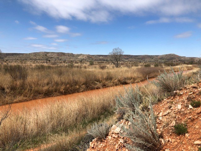 The Canadian River along Mullinaw Trail on a sunny day.  The river is bright orange.