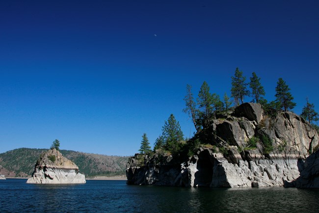 A landscape view of the lake with a rocky shoreline.