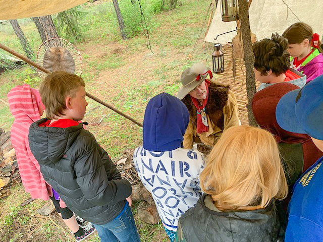 Students eagerly watch a reenactor demonstrate a traditional craft.