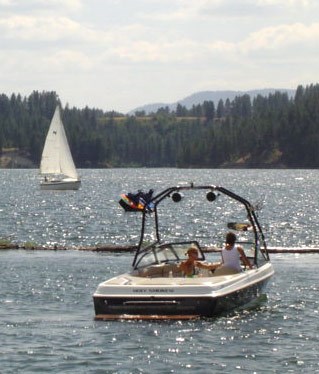Motor boat on the lake with sailboat in the background.