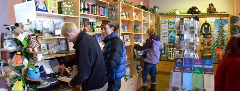 Two mean and a woman browse items in a small store