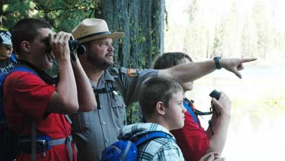 Students and a park ranger spot a bird at Manzanita Lake.