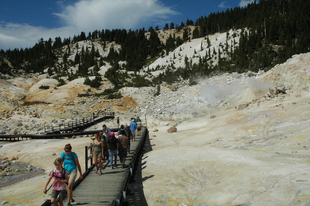 visitors walking on boardwalk at Bumpass Hell viewing hydrothermal features