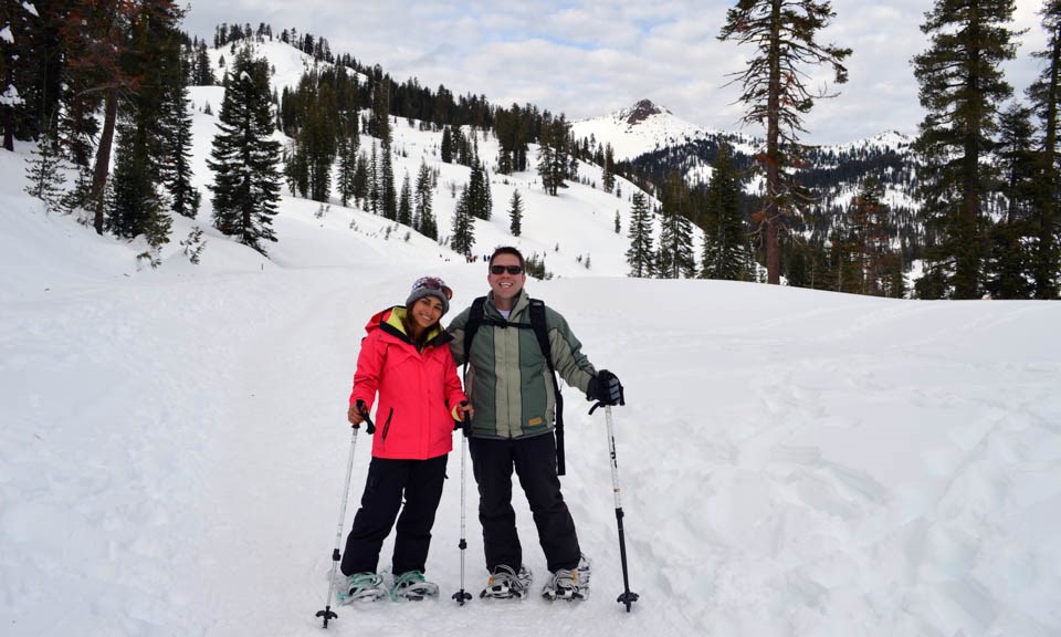 A man and a women on snowshoes in a mountain landscape.