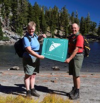 Hikers holding a trail challenge bandana