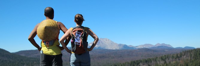 Two hikers view Lassen Peak from Cinder Cone