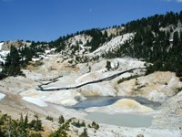 View of Bumpass Hell boardwalk winding through thermal areas with grey and yellow thermally altered earth. View of Bumpass Hell boardwalk winding through thermal areas with grey and yellow thermally altered earth.