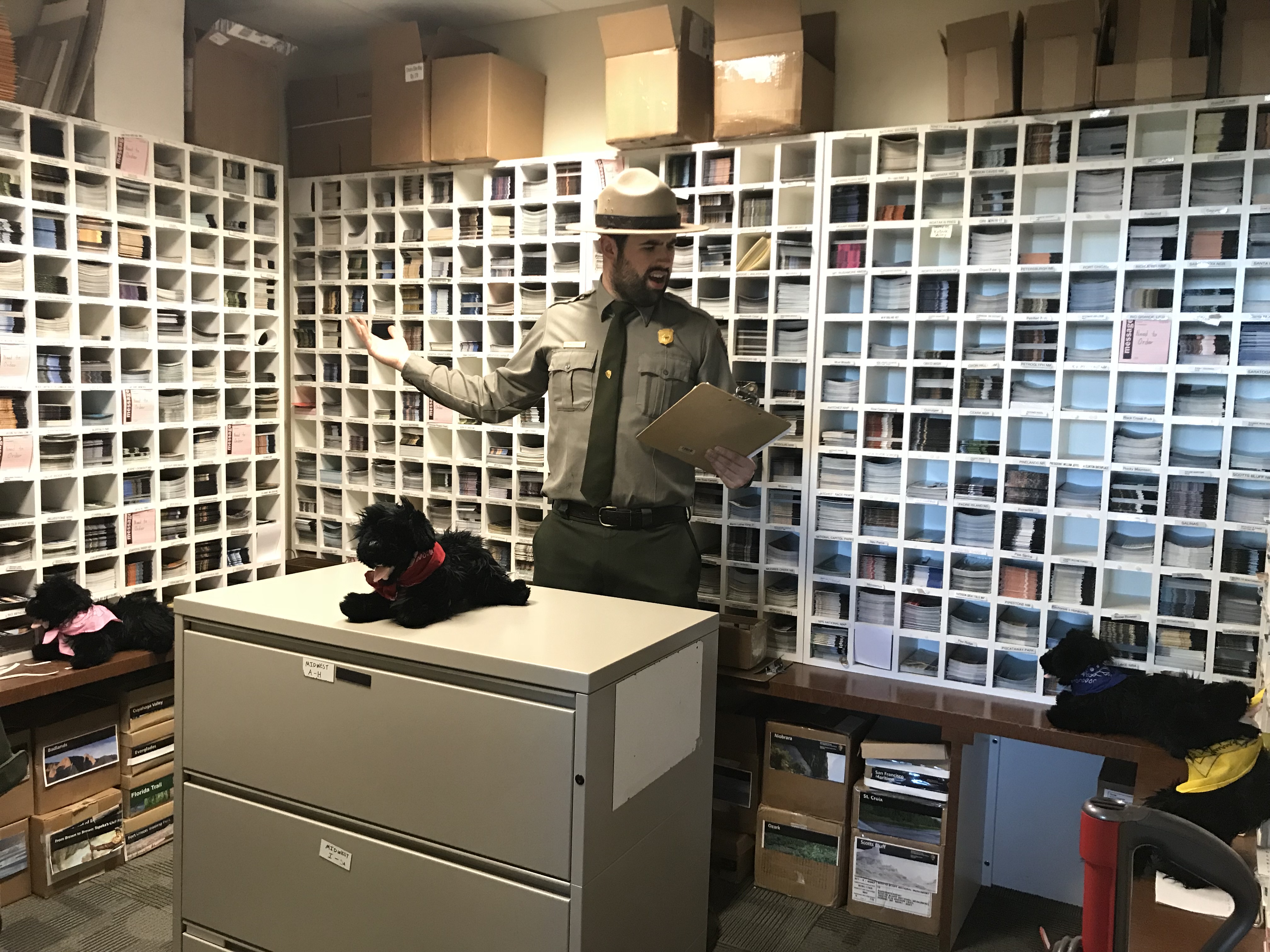 Behind the Scenes in the Brochure Room Ranger with clipboard shows the pups the brochures