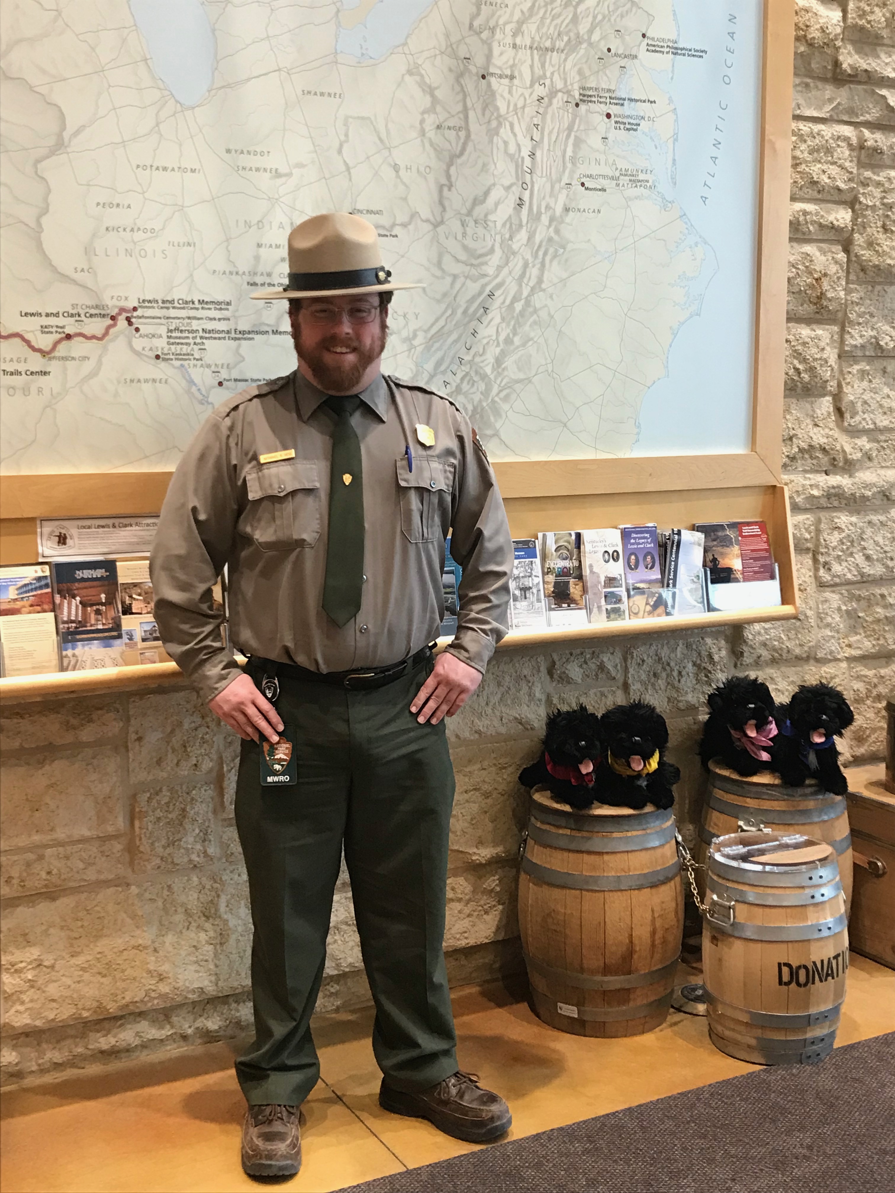 Ranger stands in front of map with pups