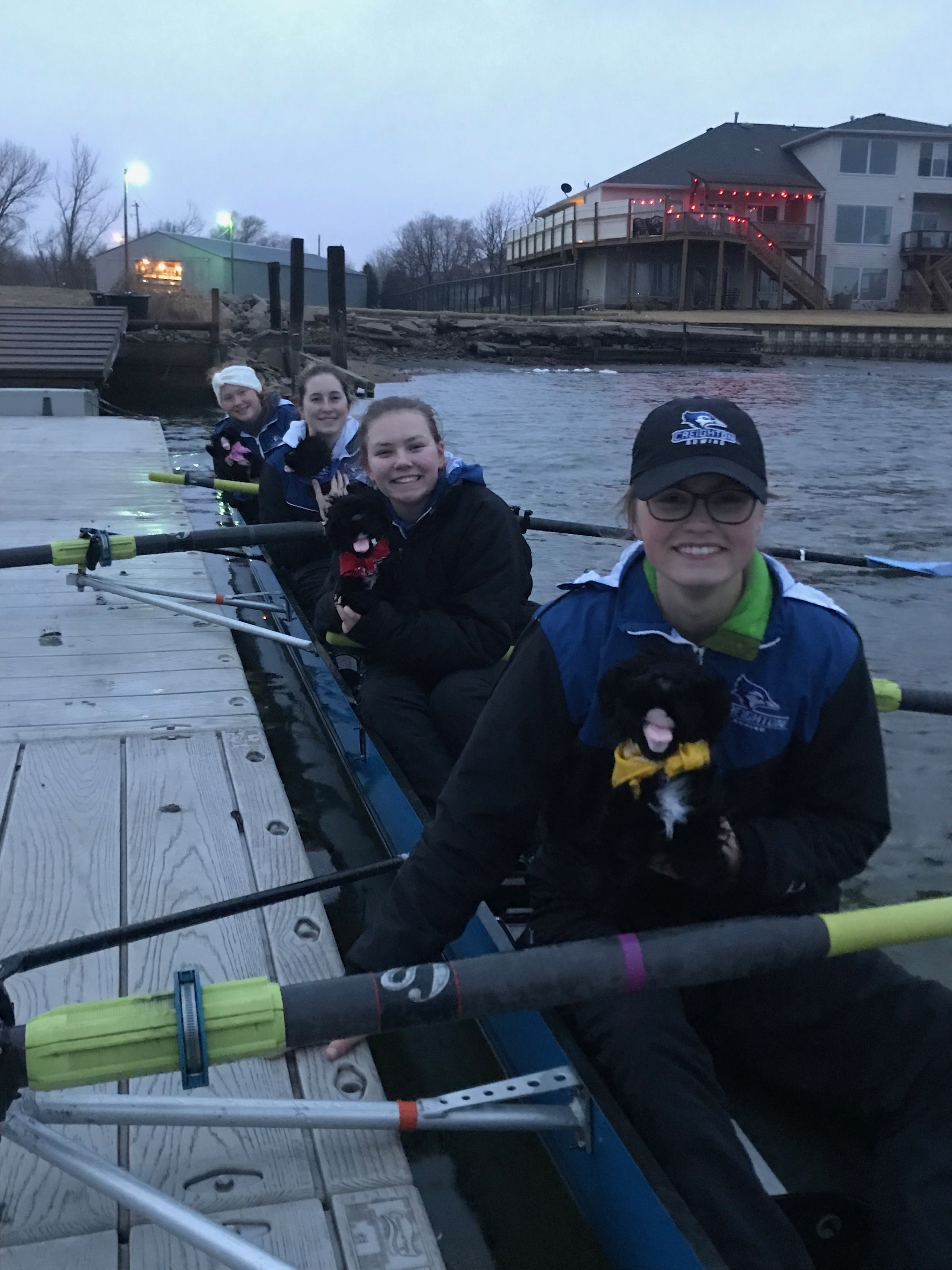 Pups being held by woman in row boat