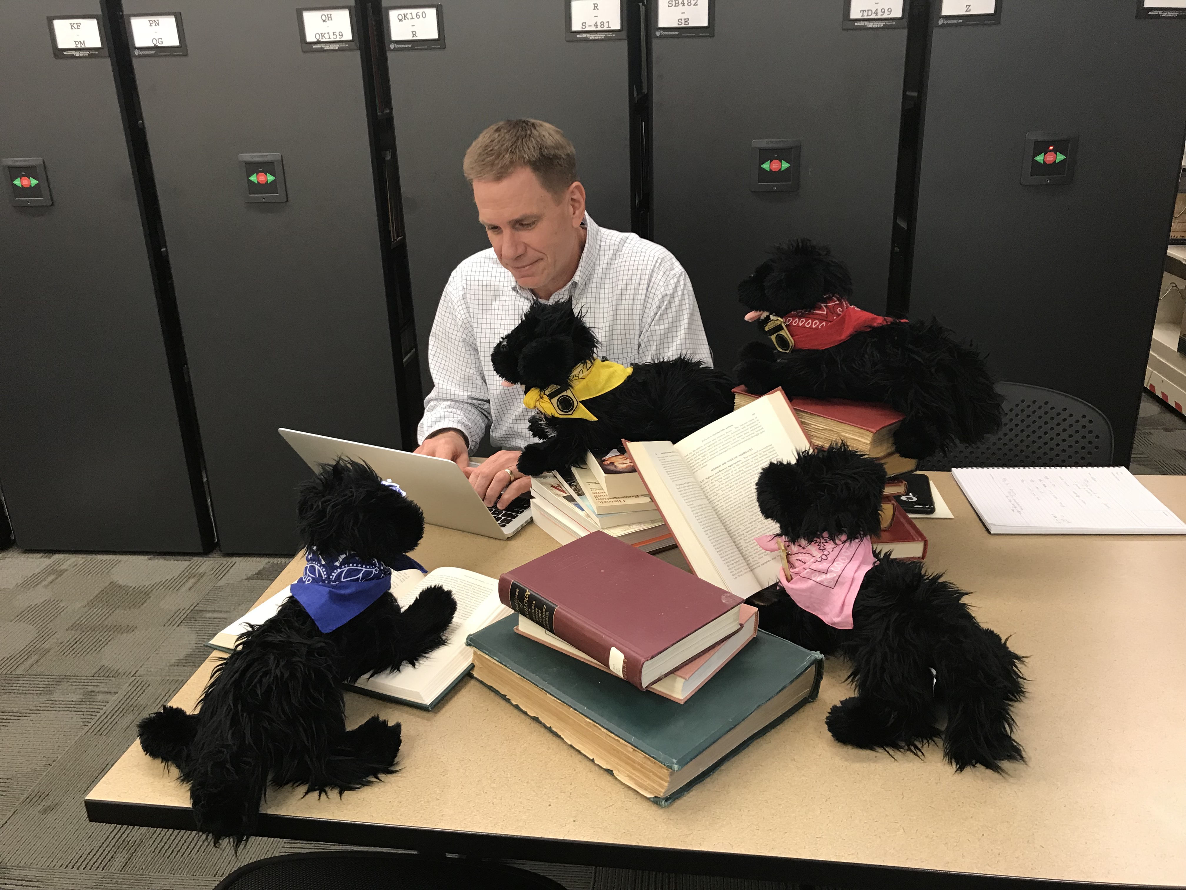 Man sitting at table reading books 