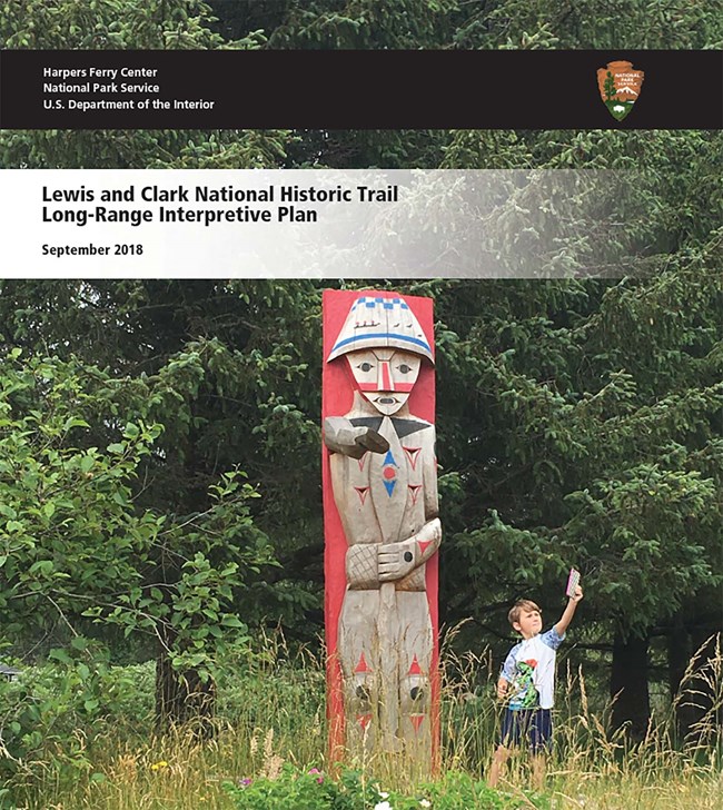 boy standing near totem pole