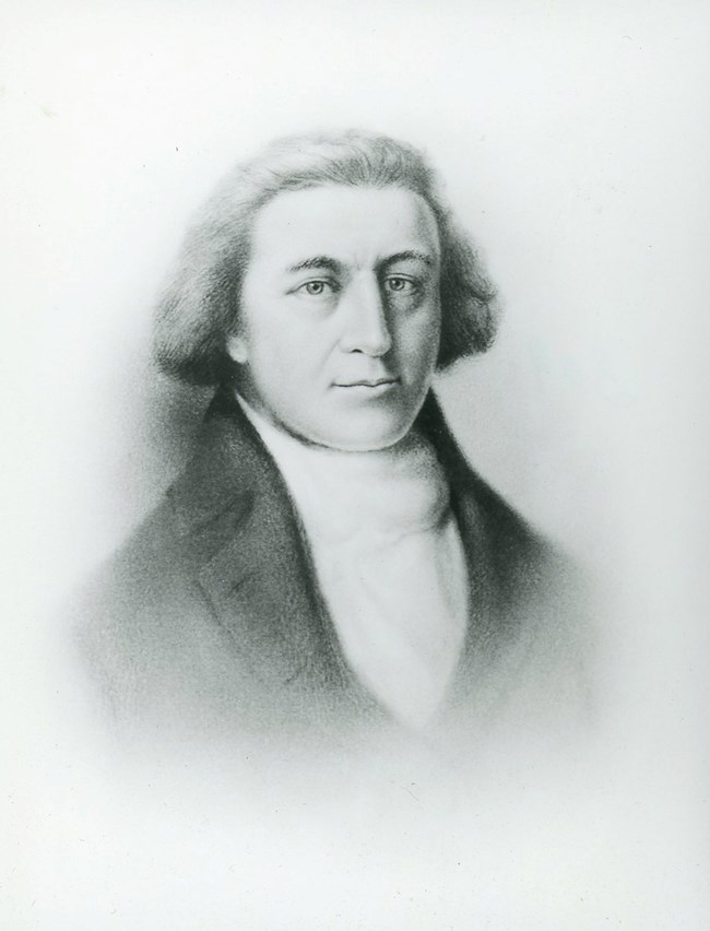 Portrait of middle aged man of the late 1700s upper class. His hair is pulled back below his ears. He wears a white shirt and black jacket.