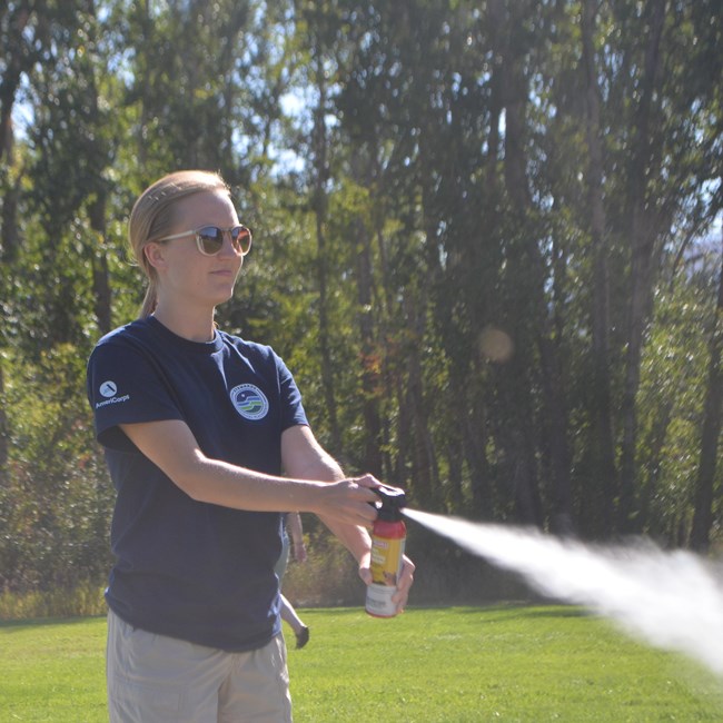 a woman spraying bear spray