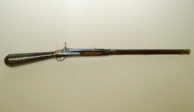 Old-fashioned gun on beige background.