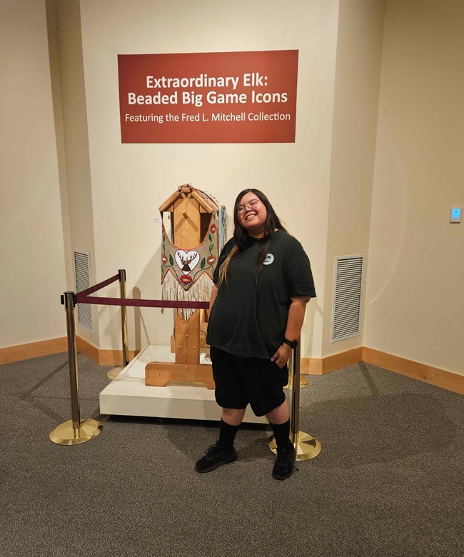 a woman standing in front of a museum display
