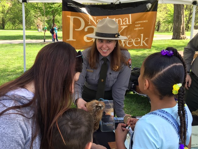 Ranger in uniform smiles as she talks to a small group.