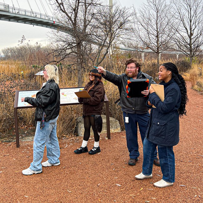 four people stand in a garden
