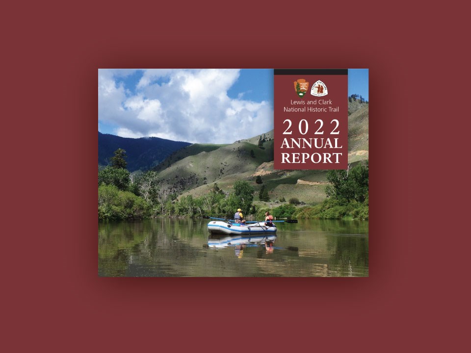 Horizontal cover reads 2022 Annual Report Lewis and Clark Trail. Photo of two people sitting on a raft. Rolling mountains reflect in the water. NPS logo, Lewis and Clark Trail logo.