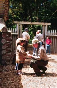 ranger helping young explorer try on buck skins