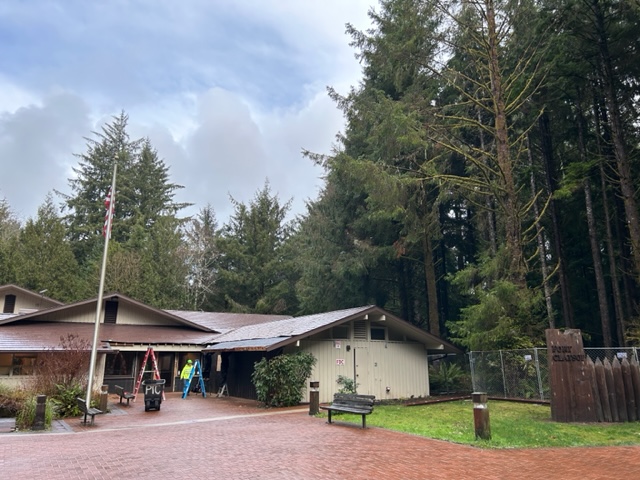 Fort Clatsop Visitor Center remodel Front of the visitor center surrounded by a chain link fence.