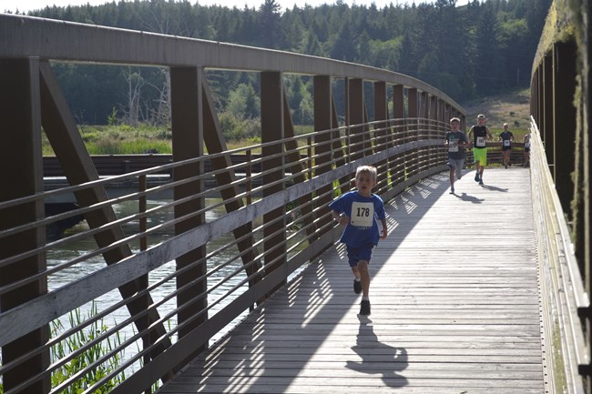 Runners crossing bridge