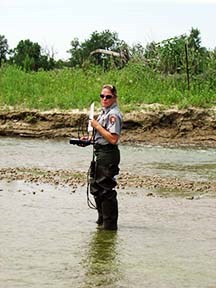 NPS employee taking a water sample.